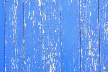 Bright blue vertical panelled wood with peeling paint and space for copy