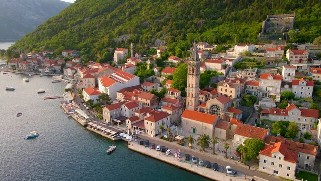 A stunning aerial view of the charming city of Perast in Montenegro, where the Bell Tower in the church of Saint Nikolas stands out as a focal point. Shot using a drone, the footage captures the city
