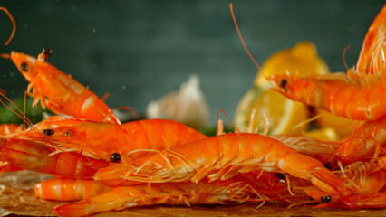 Falling prawns on black stone table, close-up