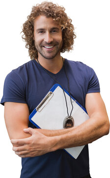 Fototapeta Smiling handsome trainer with clipboard in gym