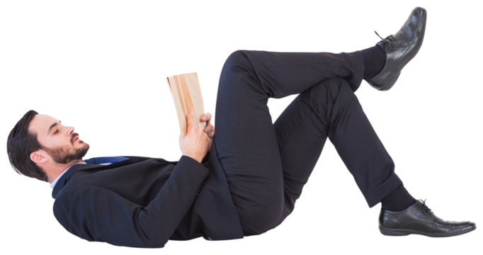 Businessman lying on the floor reading a book