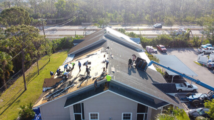 Workers repairing a roof damaged by Hurricane Ian in Fort Myers, FL - obrazy, fototapety, plakaty