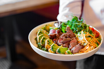 chef holding Roast beef salad with vegetables in hand