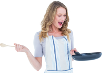 Smiling woman holding frying pan and wooden spoon 