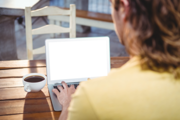 Man using laptop in cafeteria