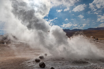 Steaming vent on the El Tatio geyser field in the high Andes of northern Chile backlit by the sun
