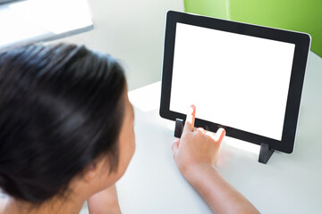 Girl pointing at digital tablet on table
