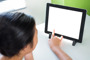 Girl pointing at digital tablet on table