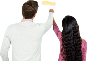 Rear view of couple holding paint roller
