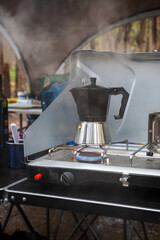 Moka coffee pot on a camping stove with steam