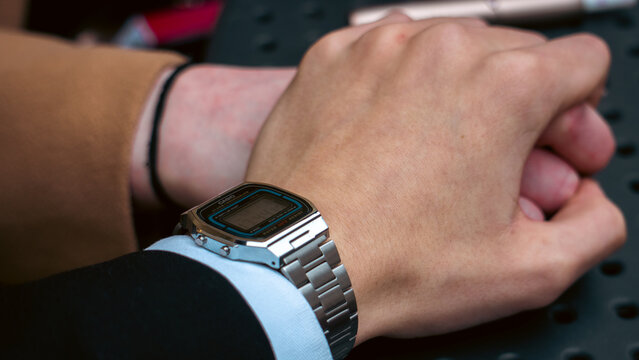 Holding hands of couple with "Casio" watch