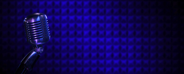 Podcast vintage microphone in recording studio. Radio broadcast or music background with copy space. Retro mic and acoustic foam texture in the dark with blue lighting for audio content banner