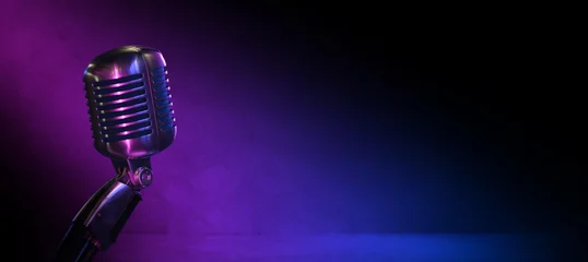 Vintage vocal microphone in the dark with pink and blue lighting and copy space for podcast banner background or jazz club, comedy club or music content © OneClic