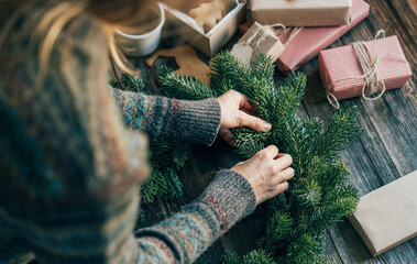 Woman makes a fir wreath for advent. Christmas Eve and crafting decorating. New Year celebration.