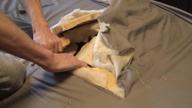 The man cut the spring mattress with a knife. Spring block and foam lining