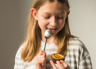 The girl eats fresh passion fruit  maracuja with a spoon with great pleasure. The concept of a...