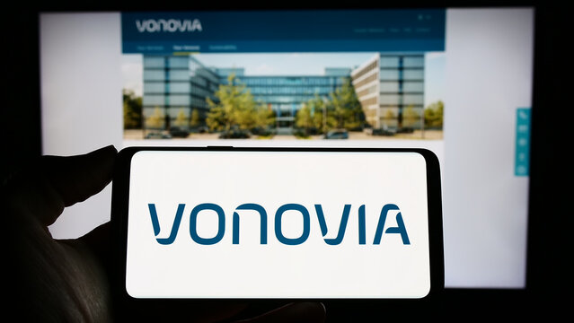 Stuttgart, Germany - 04-04-2023: Person holding smartphone with logo of German real estate company Vonovia SE on screen in front of website. Focus on phone display.