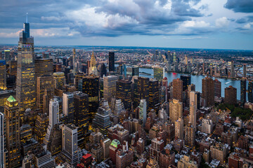 An illuminated midtown of New York City and rainy clouds above.