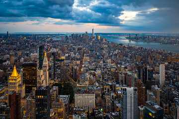 The illuminated lower Manhattan and dark blue rainy clouds.