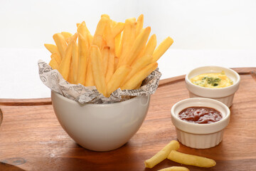 a bowl with a portion of fries mstarda sauce and katcup, on a white background