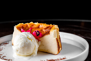 Basque Cheesecake on white dish with ice cream