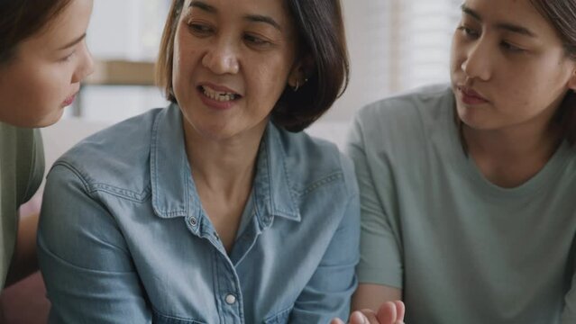 Asia people adult child help middle aged old mom crying grief loss tired hold hand stress relief talk with love care at home. Young woman listen to older mum pain sad worry lost in life crisis issues.