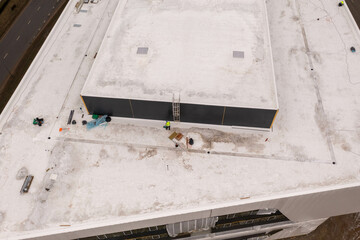 Drone photography of constructions site and construction workers finishing construction work during spring cloudy day.
