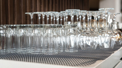 Row of drinking glasswares are prepared on the counter bar, ready for service to customer. Drink object, close-up and selective focus.