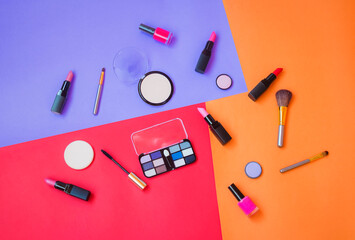 Makeup cosmetics and brushes on colorful background