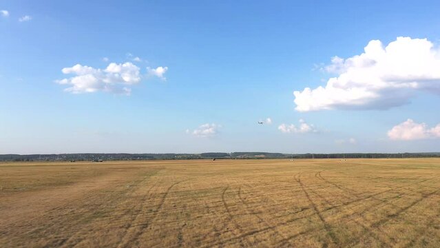 Small airplane with propeller engines flying in a clear blue sky. Aerial view to lightweight plane flight above rural airport. Travel at ultralight sport aircraft. Aviation concept. Drone shot