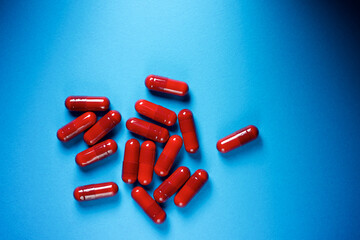 Medication capsules on a blue table