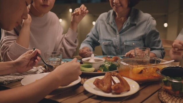 Enjoy eat yummy thai food with rice curry and drink at dine table outdoor house night party with mum. Asia older people mom and young adult child smile relax meet happy picnic meal warm time talk fun.