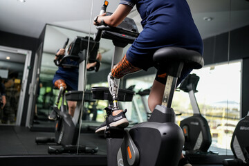 Portrait of disabled athlete woman with prosthetic leg in fitness. Closeup on bionic prosthetic leg.