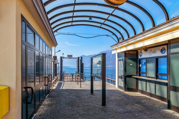 Ascona, Switzerland - March 20th, 2023: Pier in Ascona on Lago Maggiore in Switzerland. Information tables read in Italian: 