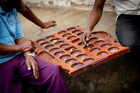 Men playing the famous Bao board game in the street, Stone Town, Zanzibar, Tanzania