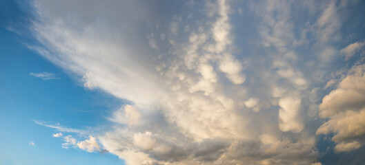 Obraz premium panorama sky background with high cirrus and lighted mammatus clouds