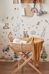 Fototapeta na wymiar Children's educational wooden toys. Nursery decor. Scandinavian style playroom. Wicker cradle