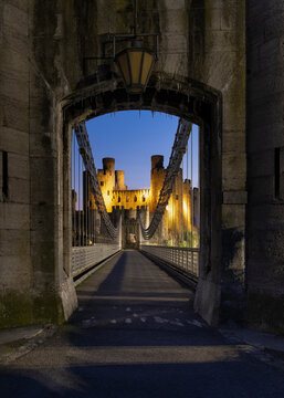 Entrance to Telford's Conwy Suspension Bridge and Conwy Castle at night, UNESCO World Heritage Site, Conwy, North Wales