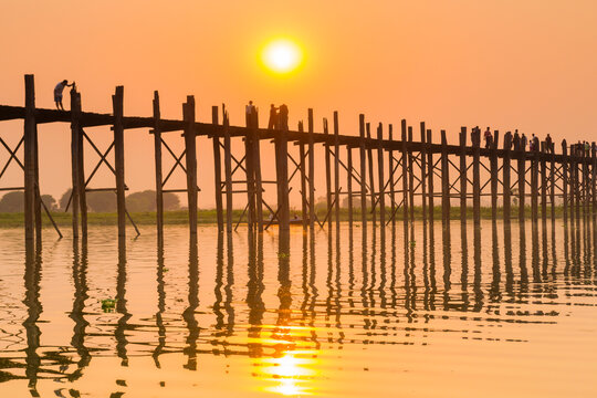 People walking on U-Bein bridge over Taung Tha Man Lake at sunset, Amarapura, Mandalay, Myanmar
