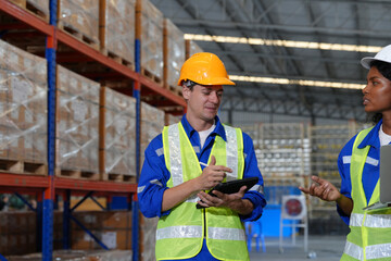 Multiethnic industrial workers checking their logistic lists while working with transportation of goods in warehouse