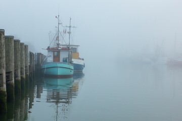 Ships moored at a pier of the North Sea on a foggy day