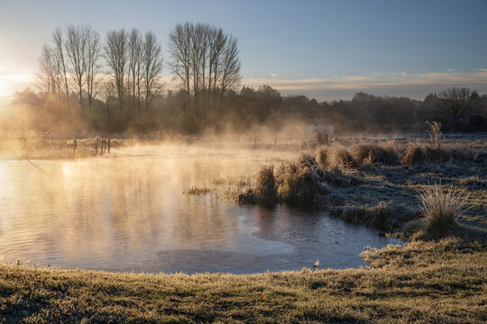 Frosty winter sunrise with mist on the River Test on Chilbolton Cow Common SSSI (Site of Special Scientific Interest), Wherwell, Hampshire