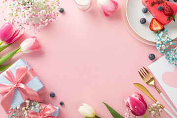 Naklejka na ściany i meble Classy Mother's day table setting. Top view flat lay of plates, cutlery, tulips, gift box, and cake with berries on pastel pink background with empty space for text or advert