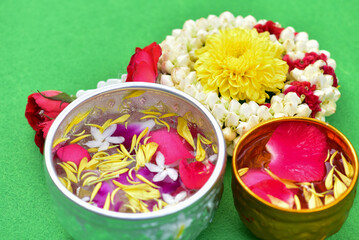 Obraz na płótnie Canvas Jasmine water and rose petals in a bowl for Songkran festival in Thailand. with space for text.