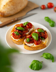Bruschetta with Ricotto cheese and cherry Tomatoes, basil, garlic on a grey concrete background. Food. Food background