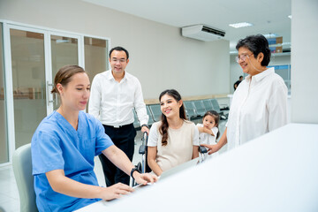 Obraz premium Asian family with young family and senior woman discuss with nurse or doctor in hallway of hospital.