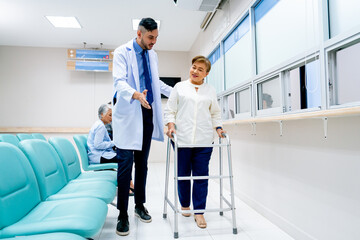 Obraz premium Portrait of Caucasian doctor help to take care and support senior patient woman with walker to walk in front of pharmacy counter in hospital.