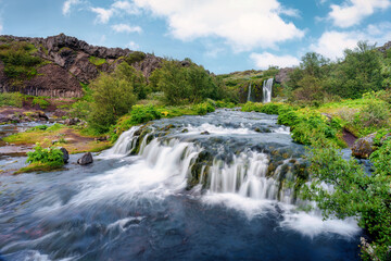 Gjain waterfall flowing with lush jungle in Pjorsardalur valley on summer at Iceland © Mumemories