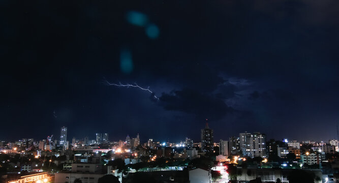 Thunderstorm with lightning in a cloudy sky over the high buildings of city SANTA CRUZ DE LA SIERRA - BOLIVIA 