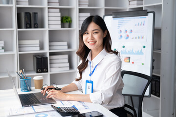 Young Adorable Asian businesswoman working in her modern office room.